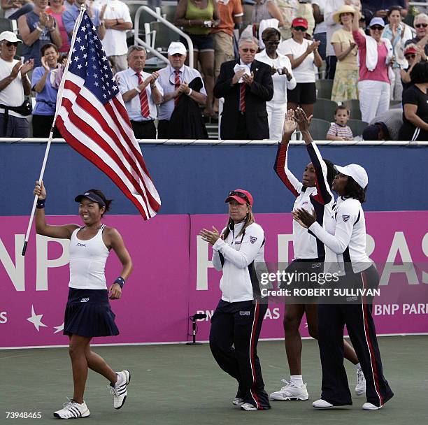 Delray Beach, UNITED STATES: Vania King carries the flag as team mates Lisa Raymond, Venus and Serena Williams celebrate their victory over Belgium...