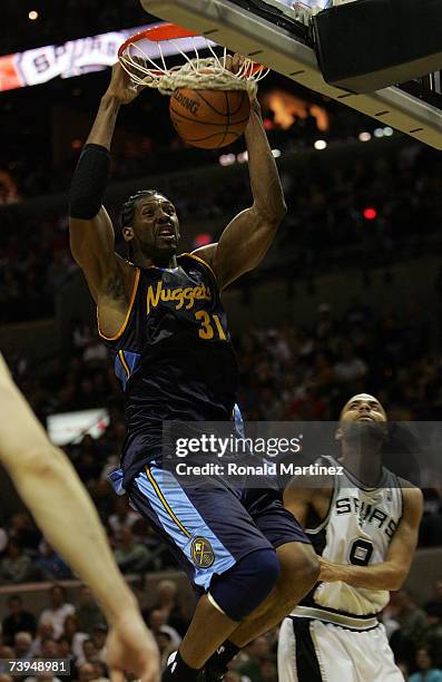 Forward Nene of the Denver Nuggets gets a slam dunk against Tony Parker of the San Antonio Spurs in Game One of the Western Conference Quarterfinals...