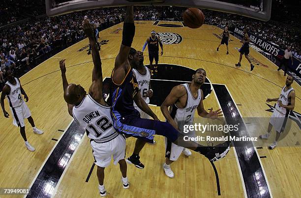 Forward Nene of the Denver Nuggets gets a slam dunk against Bruce Bowen and Tim Duncan of the San Antonio Spurs in Game One of the Western Conference...