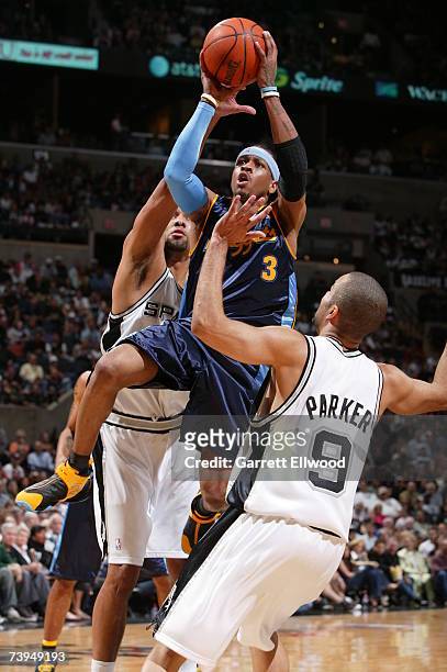 Allen Iverson of the Denver Nuggets goes to the basket against Tim Duncan and Tony Parker of the San Antonio Spurs in Game One of the Western...