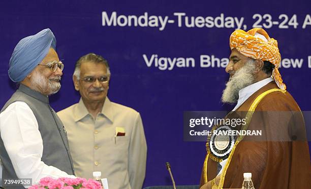 Indian Prime Minister Manmohan Singh is watched by Indian Home Minister Shivraj Patil as he speaks with Pakistan National Assembly Opposition Leader...