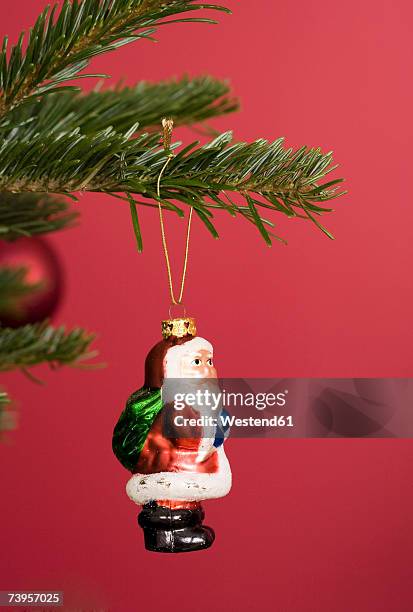 santa christmas ornament hanging on christmas tree, close-up - santa close up stock-fotos und bilder