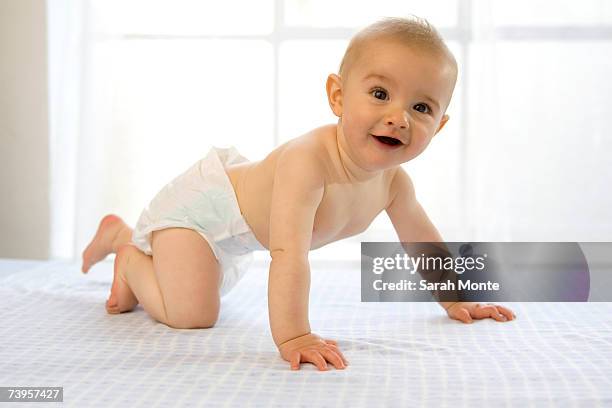baby boy (6-12 months) crawling, laughing, side view - crawling stock pictures, royalty-free photos & images