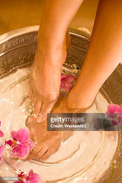 woman taking footbath, low section, elevated view - fußpflege stock-fotos und bilder