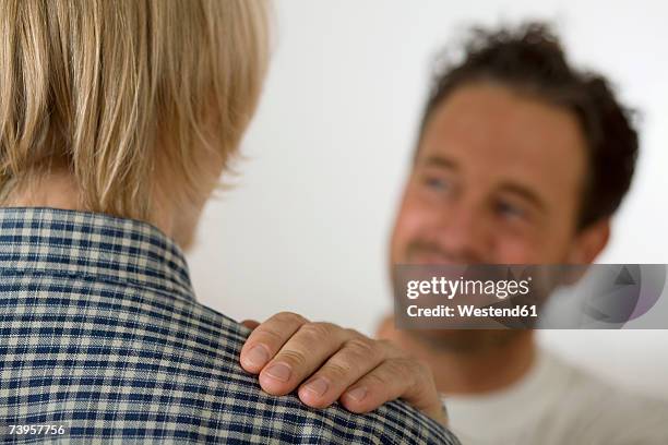 father with son (16-17), close-up (focus on foreground) - pat on the back stockfoto's en -beelden