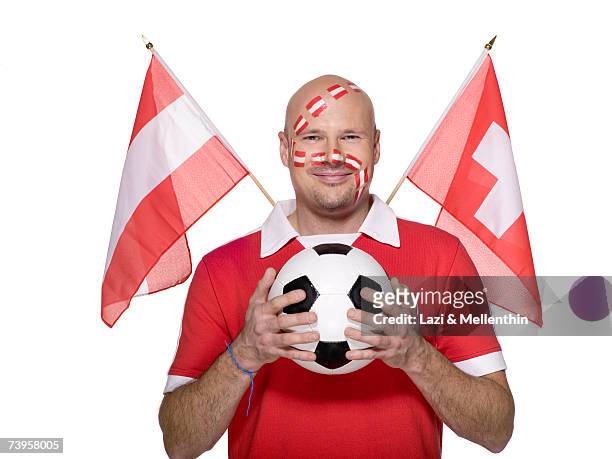 man with austrian flag painted on face, austrian and swiss flag aside - football for hope stock-fotos und bilder