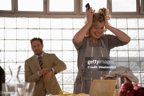 mature couple in kitchen, woman tearing hair - tearing your hair out photos et images de collection
