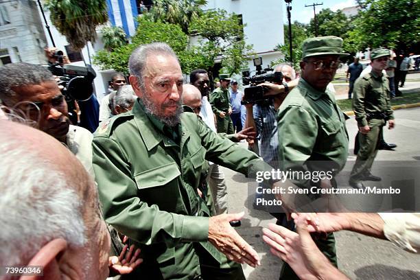 Cuban President, Fidel Castro, accompanies his security guards, and shakes hands with the crowd after casting his vote in local elections April 17,...