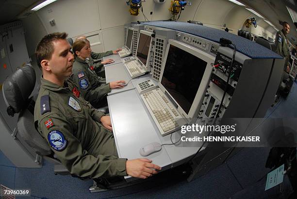 Geilenkirchen, GERMANY: Soldiers sit in front of computers in a plane of the type AWACS E-3A on the NATO airbase in Geilenkirchen, western Germany,...