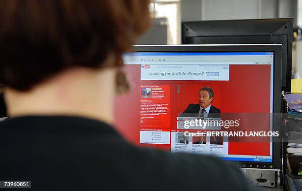 London, UNITED KINGDOM: A woman watches a screen in London, 24 April 2007, showing British Prime Minister Tony Blair answering to a reporter's...