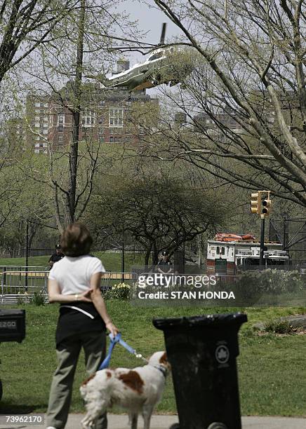 New York, UNITED STATES: Passersby watch as Marine One with US President George W. Bush onboard lands in New York's Central Park, 24 April 2007,...