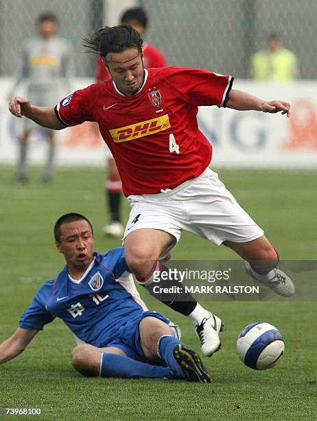 Marcus Tanaka from Japan's Urawa Reds, is tackled by Zheng Kewei from China's Shanghai Shenhua team during their Group E match of the AFC Champions...