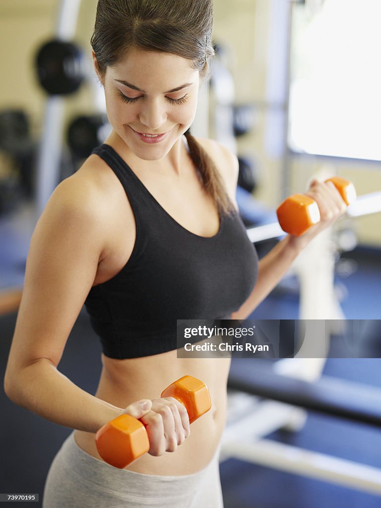 Woman doing arm curls with dumbbells