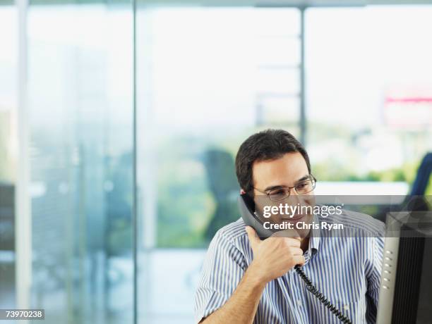 hombre hablando por teléfono en la oficina - teléfono con cable fotografías e imágenes de stock
