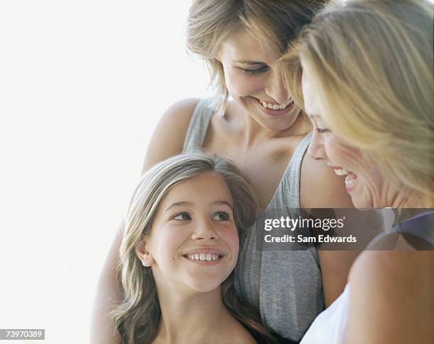 young girl laughing with mother and grandmother - generation gap stock pictures, royalty-free photos & images