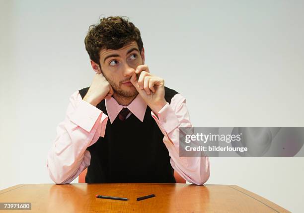 businessman sitting at conference table picking his nose - mettersi le dita nel naso foto e immagini stock