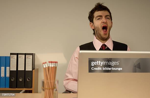 tired businessman yawning - yawn office stockfoto's en -beelden