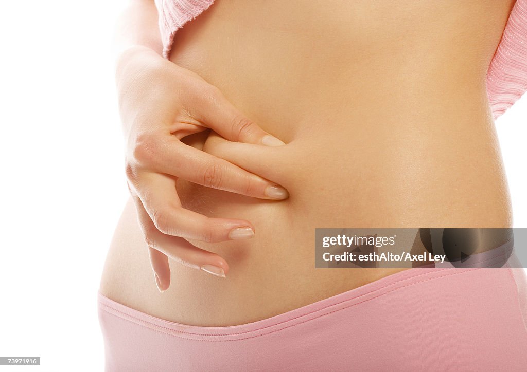 Woman pinching fat on abdomen