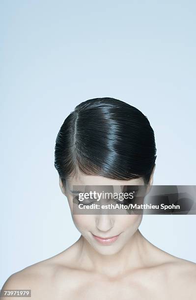 woman with short hair, bare shoulders, looking down, portrait - hair parting stockfoto's en -beelden