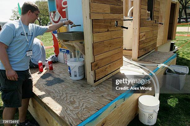 University of Virginia student Kevin Day turns off the faucet of a filter system, part of his group's innovative Learning Barge project, as the...