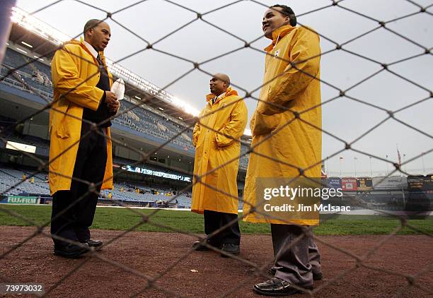 Security gaurds stand on the field after the game between the New York Yankees and the Toronto Blue Jays was called due rain at Yankee Stadium on...