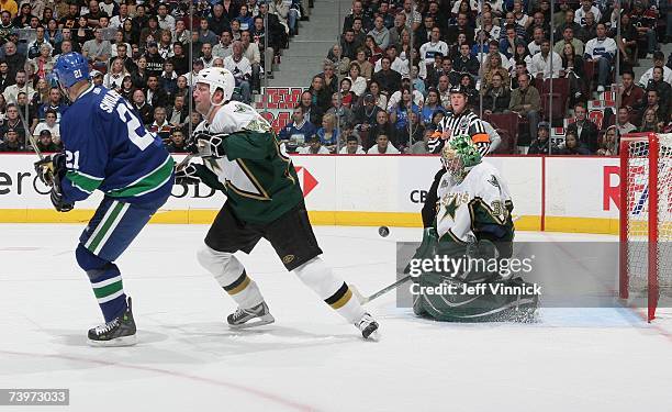 Marty Turco of the Dallas Stars makes a save as Jon Klemm defends against Bryan Smolinski of the Vancouver Canucks during Game 7 of the 2007 Western...