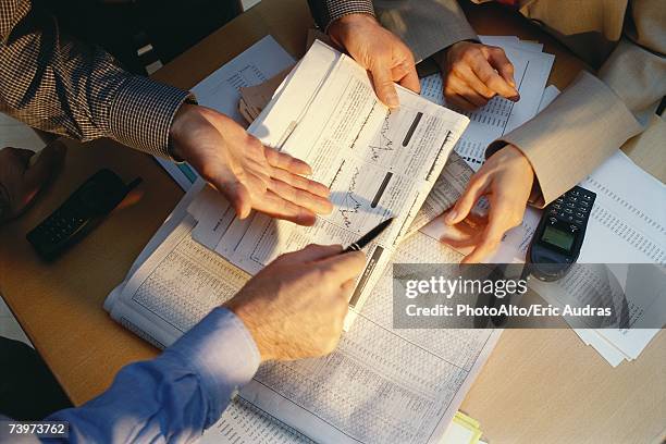 businesspeople gesturing across table to financial pages of newspaper, cropped view - aktieägare bildbanksfoton och bilder