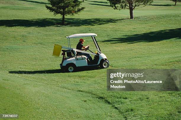 groundskeeper driving golf cart across course - golf course maintenance stock pictures, royalty-free photos & images