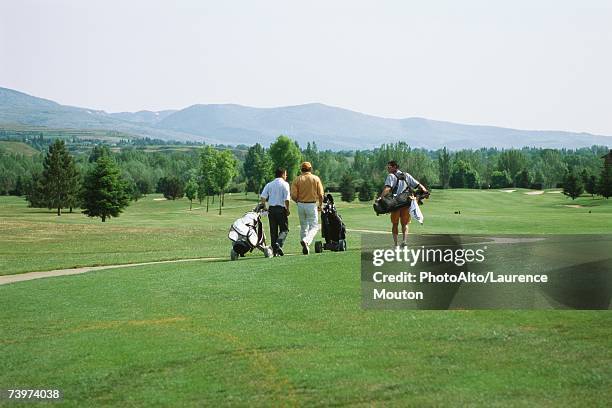 golfers walking across golf course, rear view - course caddie imagens e fotografias de stock