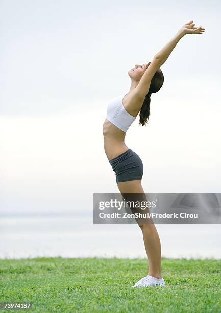 young woman stretching, side view, outdoors - salutation au soleil photos et images de collection