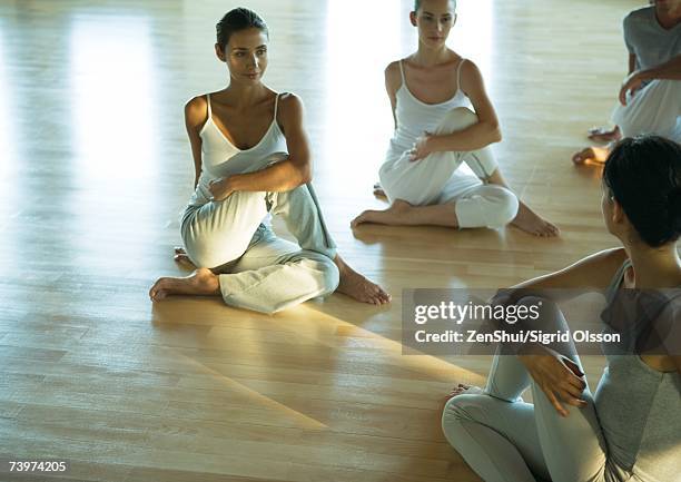 exercise class doing spinal twist - spinal twist stock pictures, royalty-free photos & images