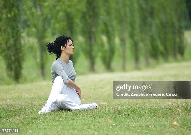 young woman stretching on grass - spinal twist stock pictures, royalty-free photos & images