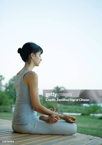 woman sitting in lotus position - soles pose stock pictures, royalty-free photos & images