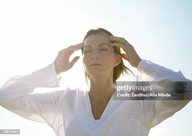 woman with hands touching temples - fortune telling stock pictures, royalty-free photos & images