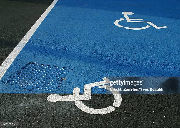 handicapped symbols on asphalt - handicap parking space stock pictures, royalty-free photos & images