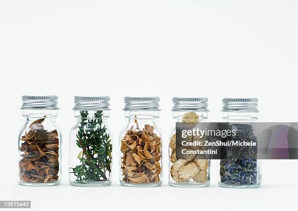 bottles of dried flowers, herbs and wood shavings - essence day stock pictures, royalty-free photos & images