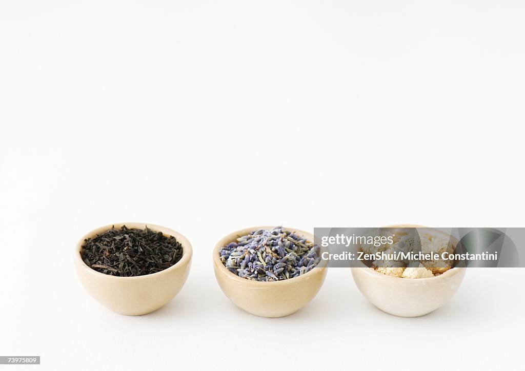 Three calabash bowls containing tea leaves, lavender, and chamomile flowers