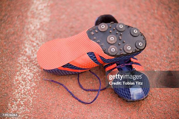 pair of running spikes on a running track - studded stock pictures, royalty-free photos & images