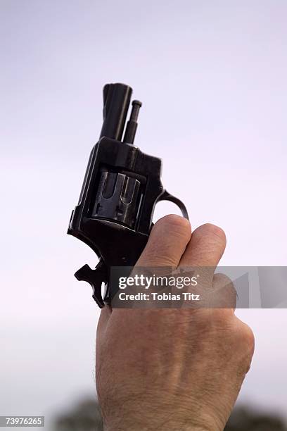 man holding a starting gun - startschot stockfoto's en -beelden