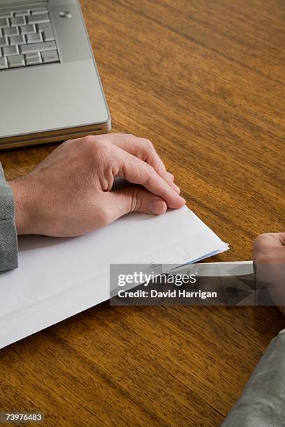 businessman opening an envelope with a letter opener - abrecartas fotografías e imágenes de stock