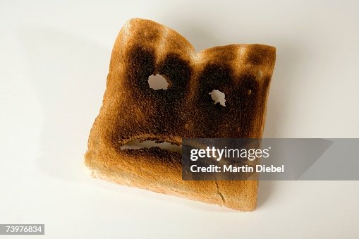 A slice of burnt toast with a sad face A slice of burnt toast with a sad face