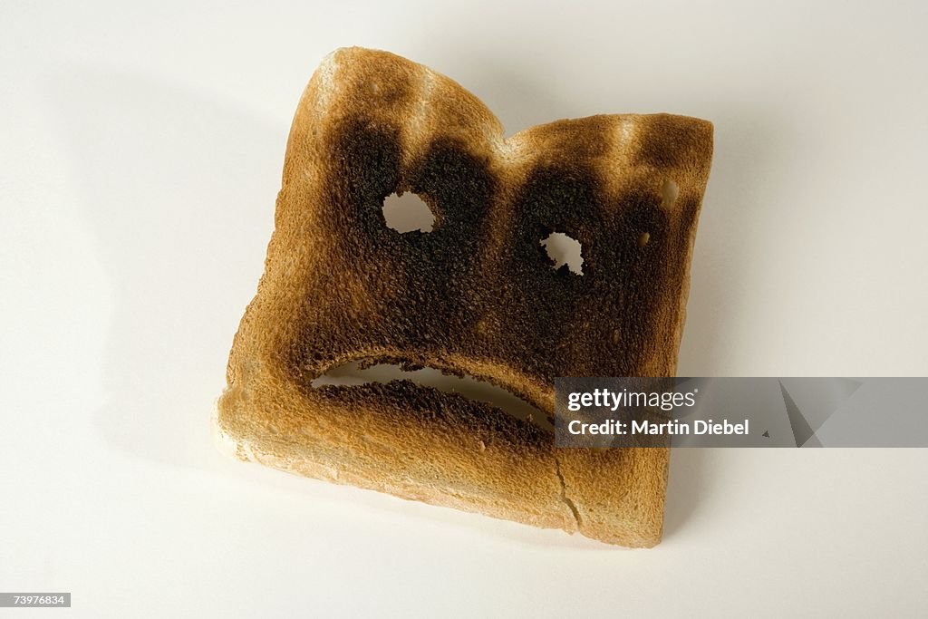 A slice of burnt toast with a sad face