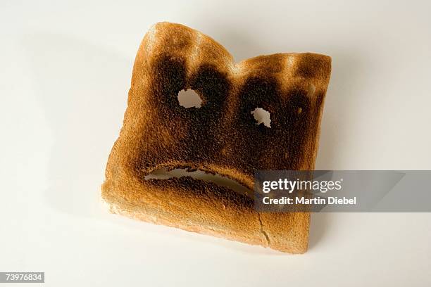 A slice of burnt toast with a sad face