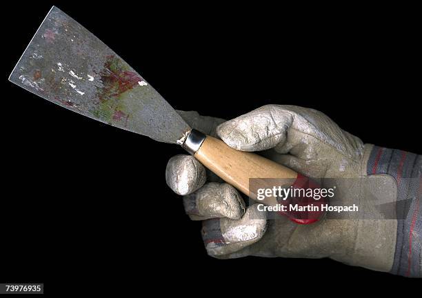 person wearing a work glove and holding a putty knife - utility knife stockfoto's en -beelden