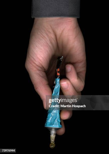 man holding a tube of glue - collant description physique photos et images de collection
