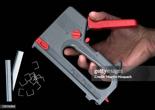 man holding a staple gun - hand holding gun stockfoto's en -beelden