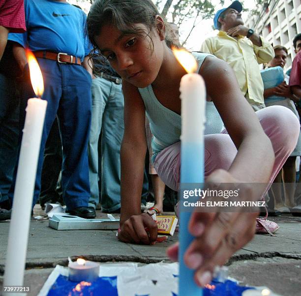 Tegucigalpa, HONDURAS: Una nina coloca una vela encendida en el suelo frente a la Catedral luego de que simpatizantes del Partido Nacional de...