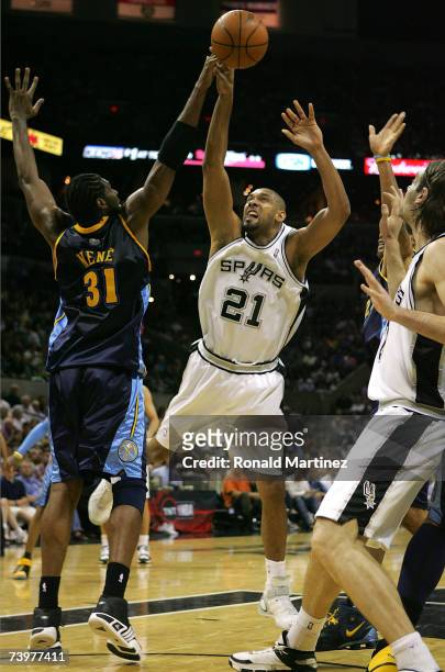 Forward Tim Duncan of the San Antonio Spurs takes a shot Nene of the Denver Nuggets in Game Two of the Western Conference Quarterfinals during the...