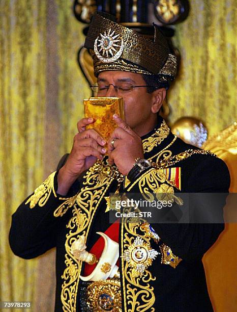 Kuala Lumpur, MALAYSIA: The thirteenth King of Malaysia, Sultan Mizan Zainal Abidin, kisses a copy of the Koran during his coronation at the National...