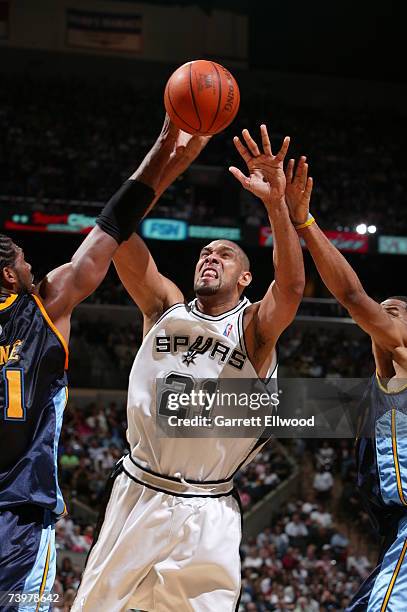 Tim Duncan of the San Antonio Spurs goes to the basket against Nene and Marcus Camby of the Denver Nuggets in Game Two of the Western Conference...